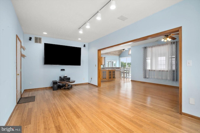 unfurnished living room with light wood finished floors, visible vents, track lighting, ceiling fan, and baseboards