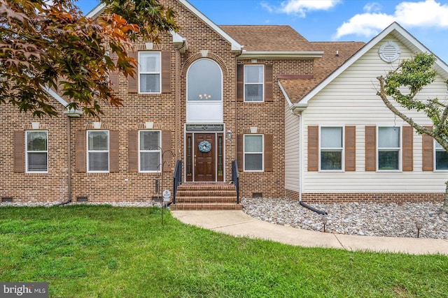 view of front facade featuring crawl space, brick siding, a front yard, and a shingled roof