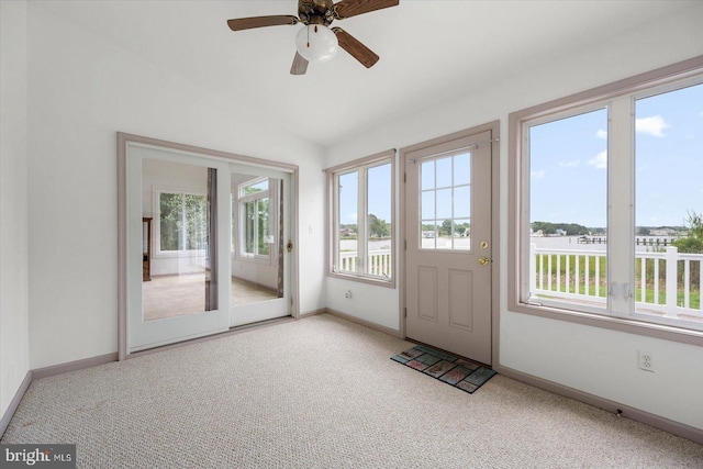 doorway featuring a wealth of natural light, carpet flooring, and ceiling fan