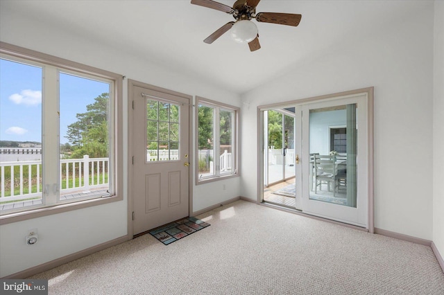 doorway with baseboards, carpet, ceiling fan, and vaulted ceiling