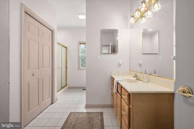 full bathroom with tile patterned flooring, vanity, baseboards, and a shower with shower door