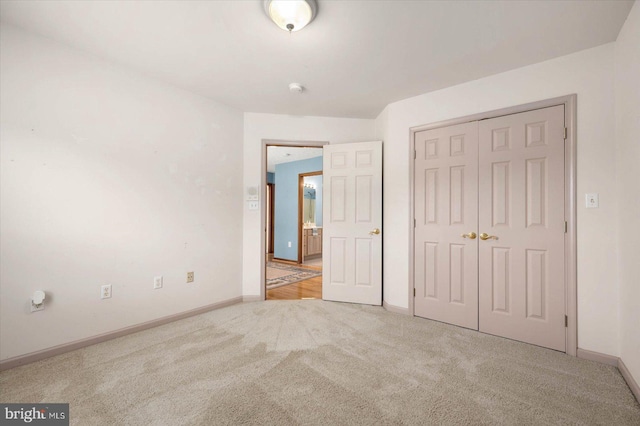 unfurnished bedroom featuring carpet flooring, baseboards, and a closet