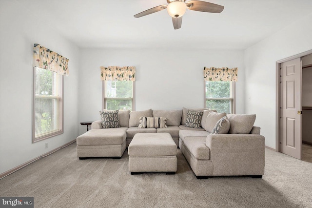 carpeted living room with a ceiling fan and baseboards