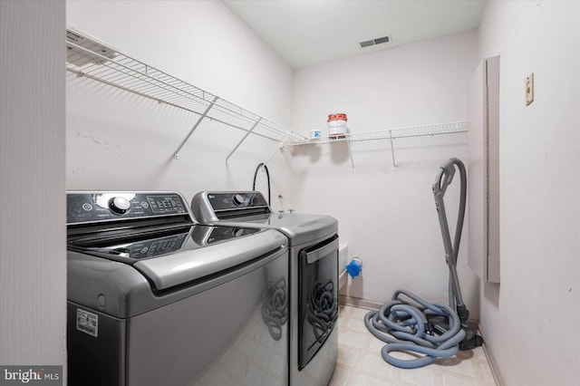 laundry room featuring visible vents, baseboards, light floors, laundry area, and washer and dryer