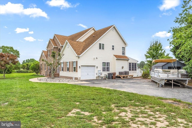 exterior space featuring a yard, a garage, driveway, and a shingled roof