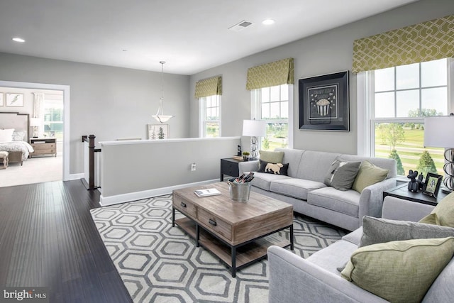 living area with dark wood finished floors, visible vents, recessed lighting, and baseboards