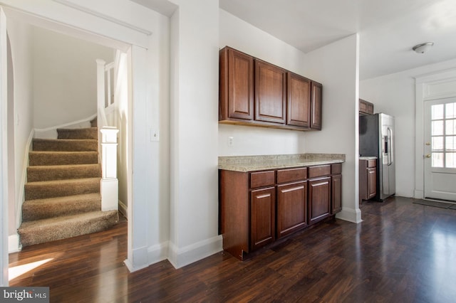 kitchen with dark wood finished floors, light countertops, baseboards, and stainless steel fridge