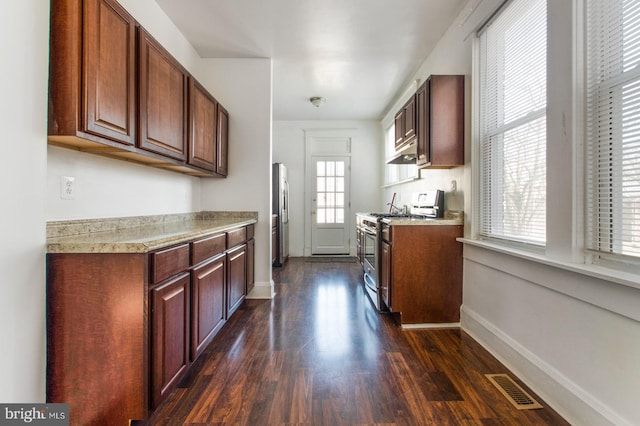 kitchen featuring visible vents, baseboards, under cabinet range hood, dark wood-style floors, and stainless steel appliances