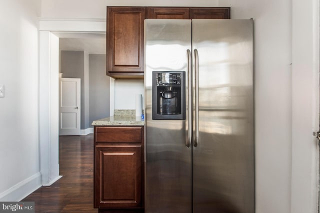 kitchen featuring dark wood-style floors, stainless steel fridge with ice dispenser, baseboards, and light stone countertops