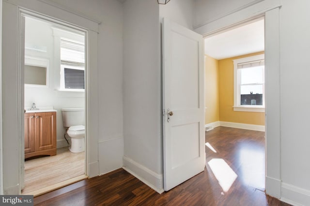 bathroom featuring vanity, toilet, wood finished floors, and baseboards