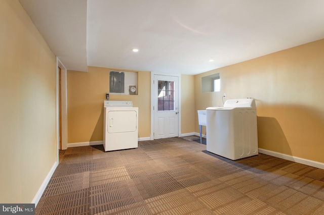 clothes washing area featuring electric panel, laundry area, washer / clothes dryer, and baseboards