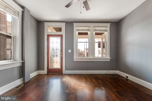 foyer with a ceiling fan, dark wood-type flooring, a healthy amount of sunlight, and visible vents