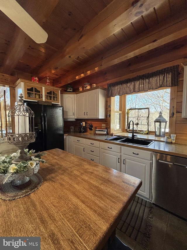 kitchen featuring beam ceiling, a sink, white cabinets, dishwasher, and black refrigerator with ice dispenser