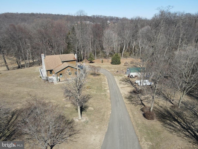 birds eye view of property featuring a wooded view