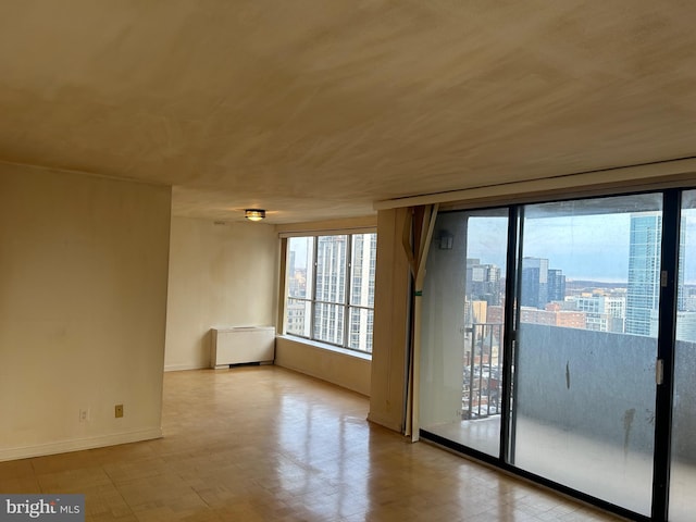 spare room with a view of city and baseboards