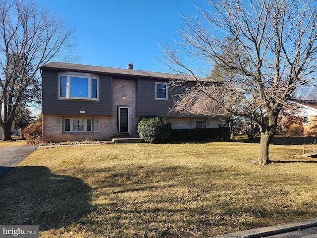 split foyer home featuring brick siding and a front yard