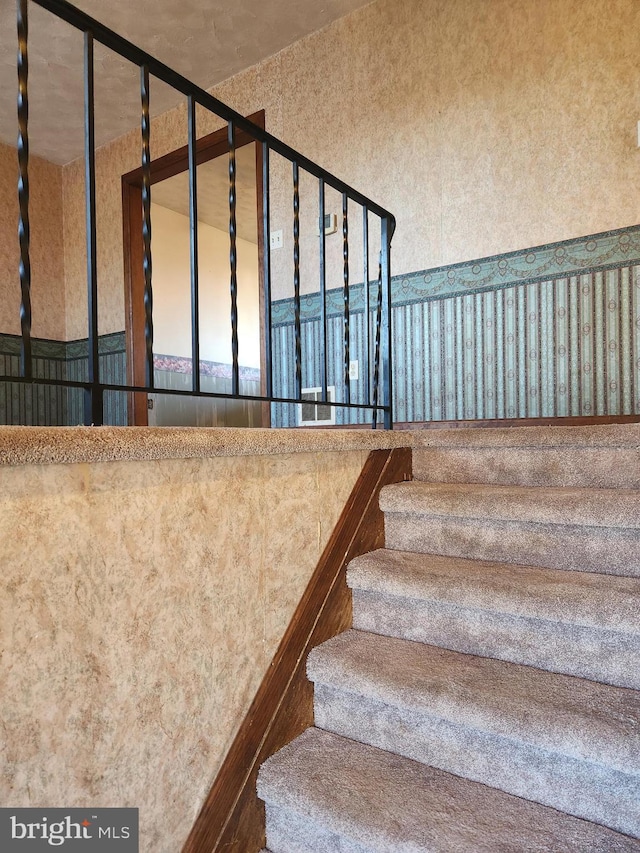 staircase with wallpapered walls