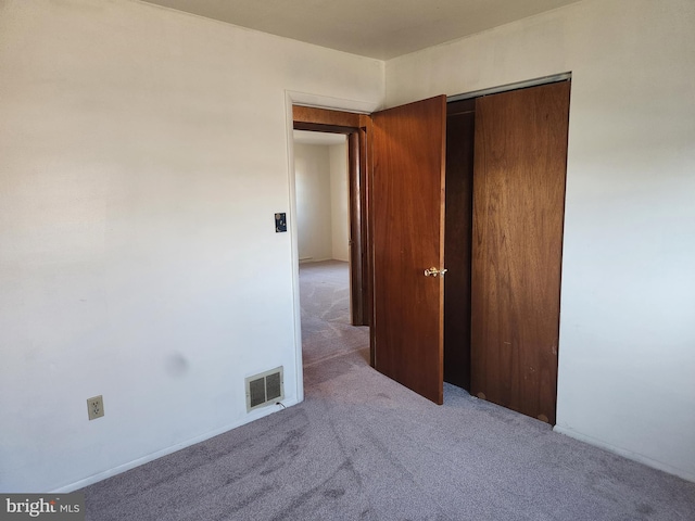 unfurnished bedroom with a closet, visible vents, and carpet floors