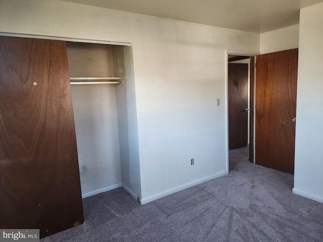 unfurnished bedroom with a closet, baseboards, and carpet