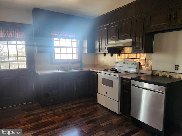 kitchen featuring dark wood finished floors, a sink, under cabinet range hood, backsplash, and white range with electric stovetop