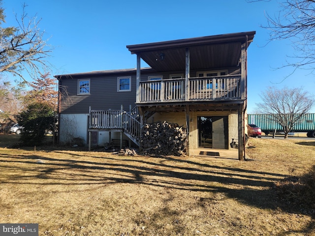 back of property featuring stairway, a lawn, and a wooden deck