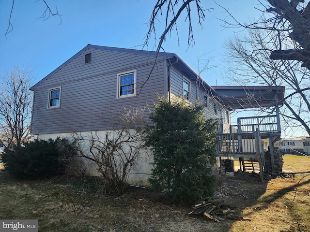 view of side of home featuring stairway and a deck