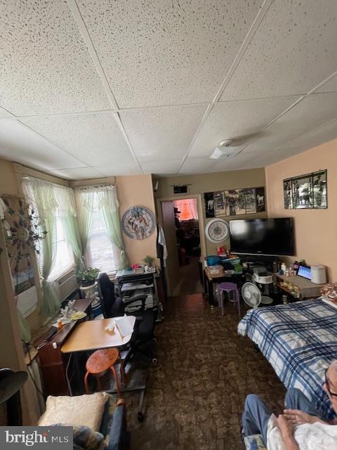 interior space with a paneled ceiling and carpet