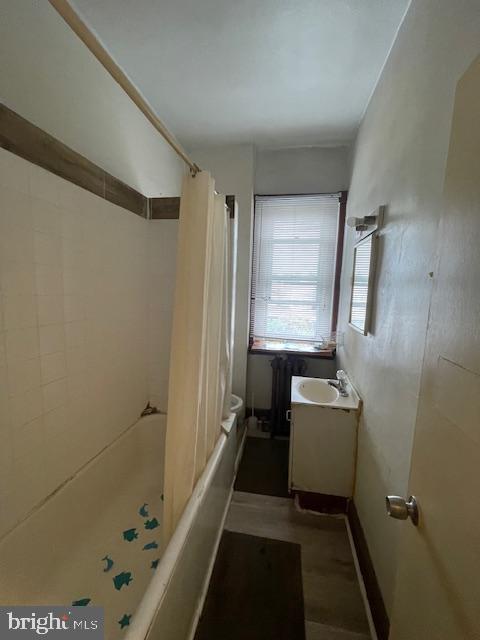 bathroom featuring shower / bath combo with shower curtain and vanity