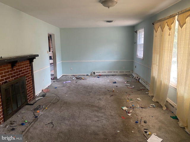 unfurnished living room with visible vents, a fireplace, and a baseboard heating unit