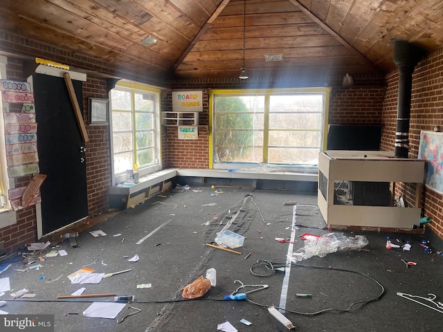 unfurnished living room with vaulted ceiling, a wood stove, wood ceiling, and brick wall