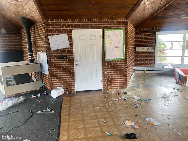 foyer entrance featuring brick wall, wooden ceiling, and vaulted ceiling