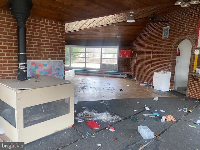 unfurnished living room with wood ceiling, brick wall, and vaulted ceiling