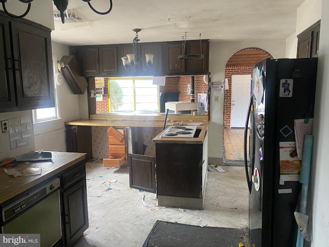 kitchen with an inviting chandelier, dishwashing machine, and freestanding refrigerator