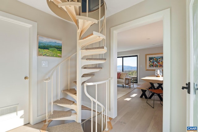 stairs with visible vents and wood finished floors