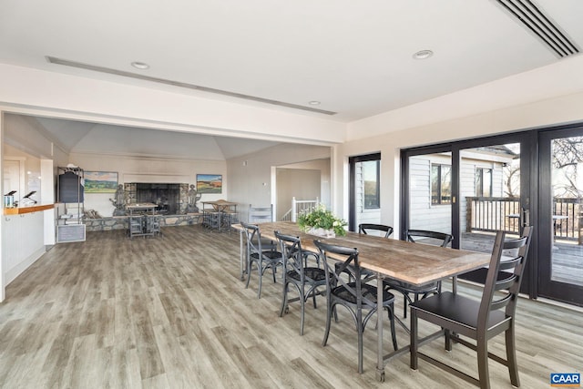 dining room featuring lofted ceiling, recessed lighting, and light wood-type flooring