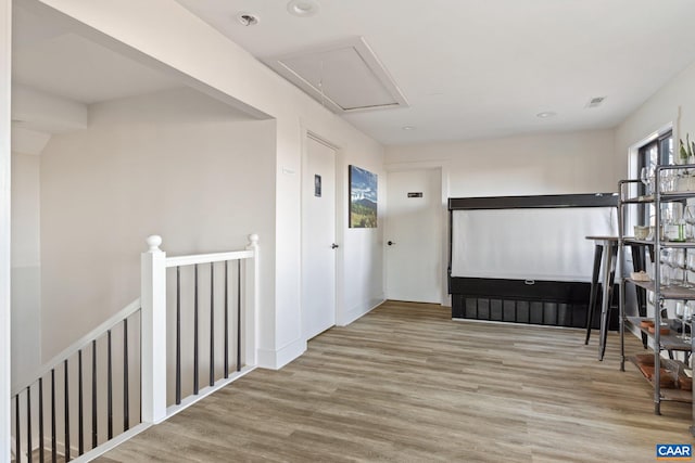 corridor with attic access, wood finished floors, an upstairs landing, and visible vents