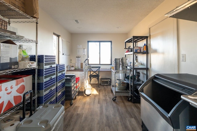 misc room with dark wood-style floors, visible vents, and a textured ceiling