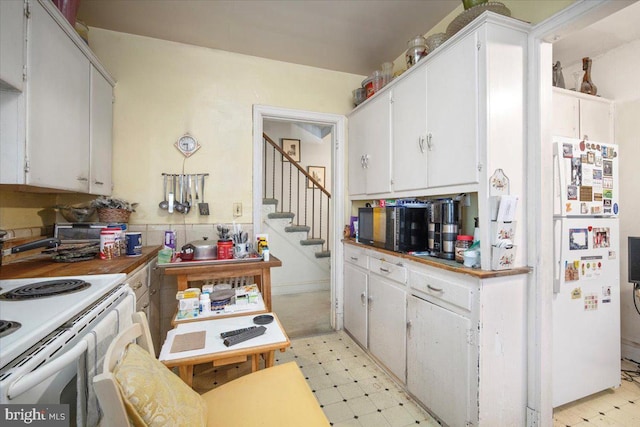 kitchen featuring white cabinetry, light floors, and white appliances