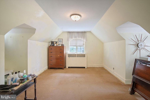 additional living space with vaulted ceiling, carpet flooring, baseboards, and radiator heating unit