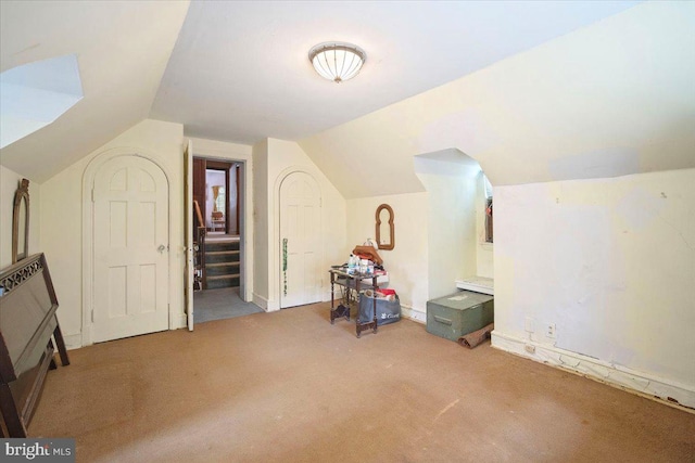 bonus room featuring vaulted ceiling, stairs, carpet floors, and baseboards