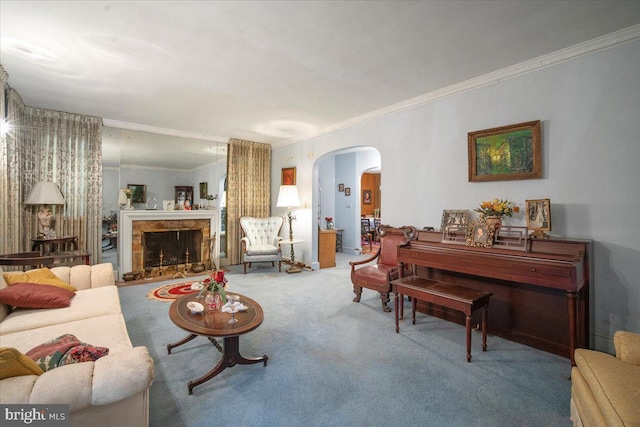 living room featuring crown molding, carpet, arched walkways, and a fireplace with raised hearth