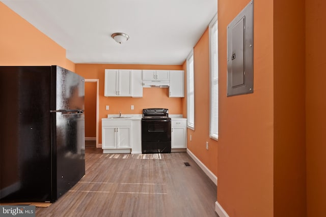 kitchen featuring electric panel, black appliances, light countertops, under cabinet range hood, and white cabinetry