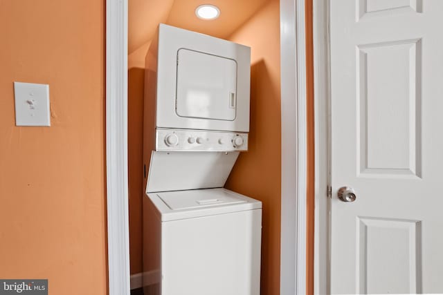 clothes washing area featuring laundry area and stacked washer / dryer