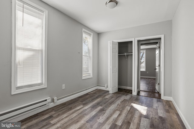 unfurnished bedroom with dark wood-style floors, a closet, baseboards, and a baseboard radiator