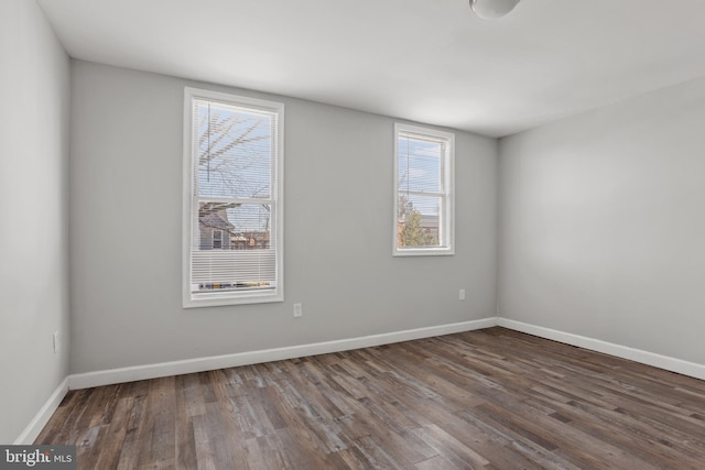 unfurnished room with baseboards and wood finished floors