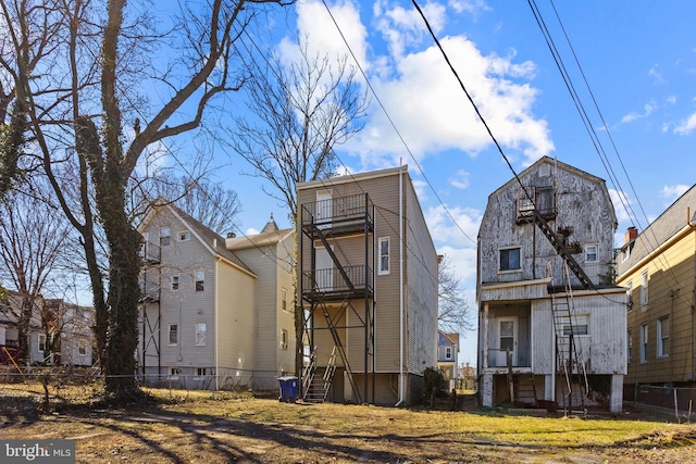 rear view of house featuring fence, central air condition unit, a gambrel roof, entry steps, and a balcony