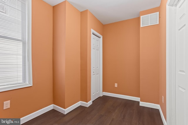 unfurnished bedroom with dark wood finished floors, baseboards, and visible vents