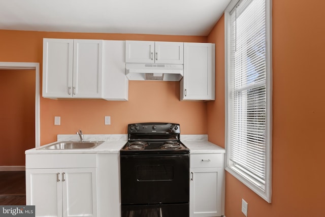 kitchen with under cabinet range hood, black / electric stove, a wealth of natural light, and a sink