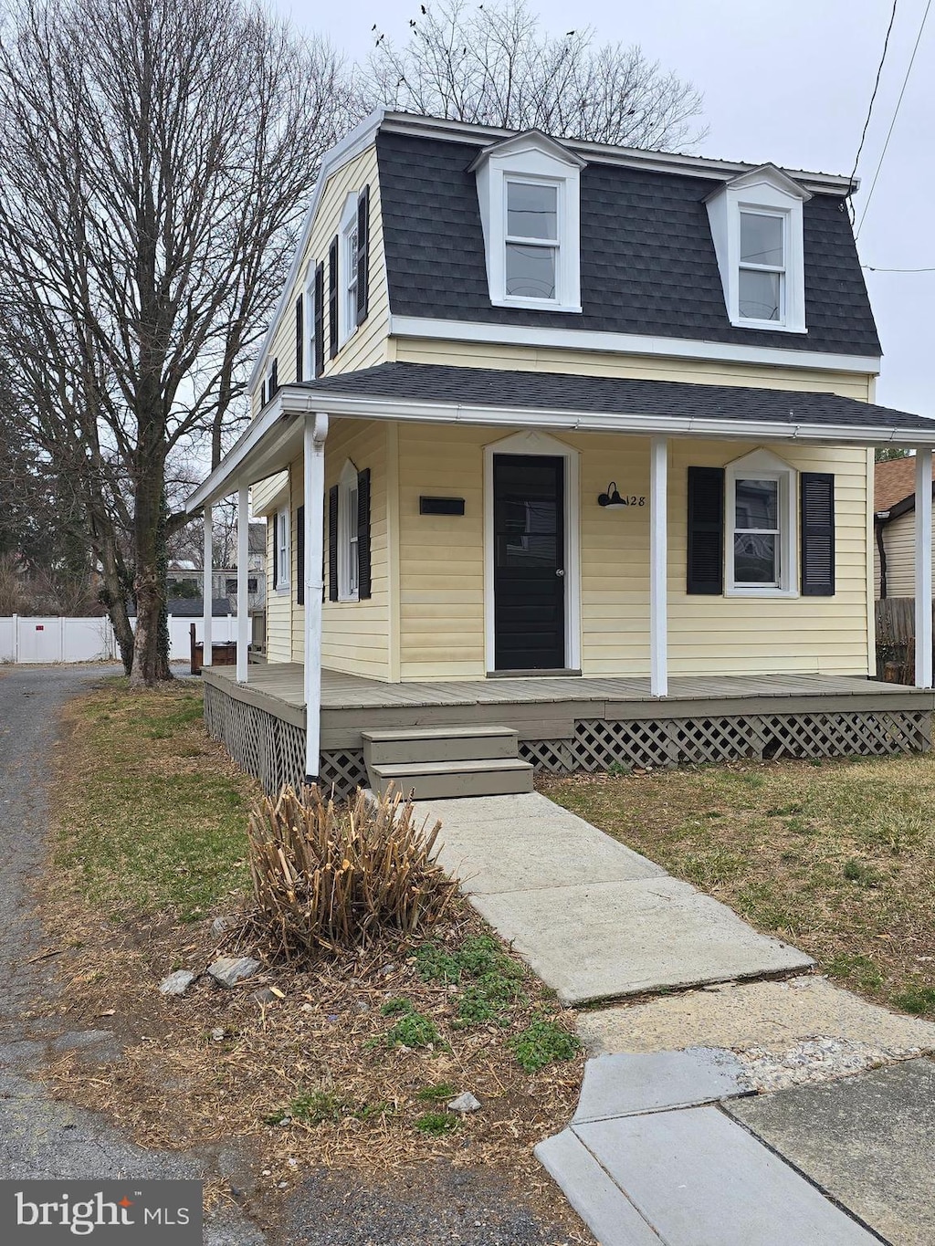 view of front facade with covered porch and a shingled roof