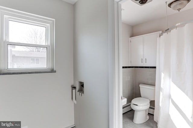 bathroom featuring tile patterned flooring, tile walls, toilet, and a baseboard radiator